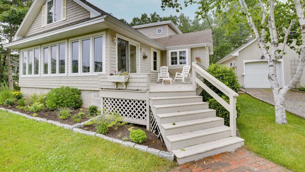 A two-story house with a covered porch, a staircase, and a small garden area. - Kennebunkport Getaway w/ Grill: Walk to Beach! (Kennebunkport)