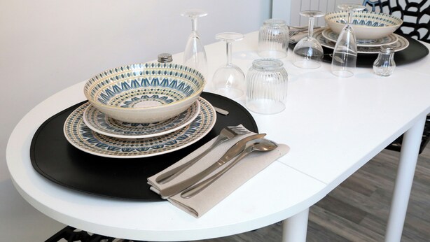 A dining table set with plates, bowls, glasses, and cutlery. - JUPITER near gare station and market (Saint-Quentin)