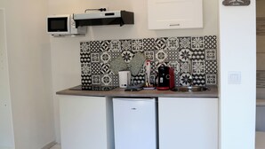 A compact kitchen with a microwave, coffee maker, and a small refrigerator. The backsplash features a black and white patterned tile design. - JUPITER near gare station and market (Saint-Quentin)