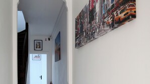 A hallway with a tiled floor, white walls, and a large mural. - JUPITER near gare station and market (Saint-Quentin)