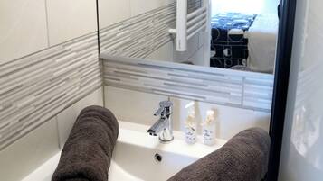 Shower, hair dryer, towels, toilet paper