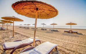 A beach with rows of sun loungers and thatched umbrellas. - Pet friendly home in Los Alcazares (Los Alcazares)