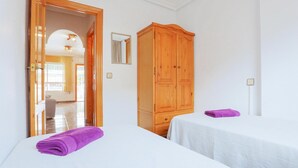 A hotel room with two beds, a wooden wardrobe, a mirror, and a bathroom visible through an open door. - Pet friendly home in Los Alcazares (Los Alcazares)