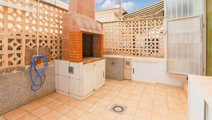 A compact outdoor kitchen area with a brick oven, storage cabinets, and a water hose. - Pet friendly home in Los Alcazares (Los Alcazares)