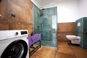 Chuveiro, toalhas de banho, sabonete, papel higiênico