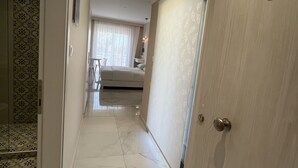A hotel corridor with a marble floor, a bed in the background, and a door marked with the number 5. - Mear Luxury Apartments and Studios (Kantanos-Selino)