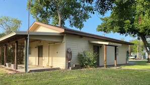 A single-story house with a covered porch, a small attached garage, and a lawn in front.