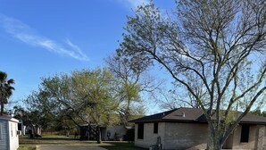 A gravel driveway leading to a row of single-story houses with attached garages.