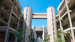 A modern building with a central atrium, multiple floors, and a symmetrical facade. - Duplex in Siwar, 1 Bedroom, Next to Rimal, Wifi (Ghazir)