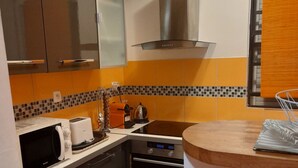 Cocina compacta equipada con microondas, tostadora, hervidor y horno.