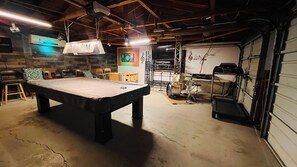 Relax and unwind in this versatile space, featuring a billiards table and a drum set for entertainment.