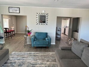 Relax in this stylish living room with a blue armchair, grey sofa, and cozy rug.