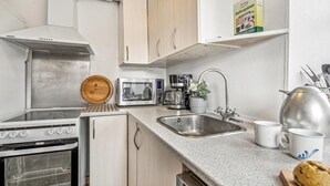 A modern kitchen with stainless steel appliances, a coffee maker, and a sink.