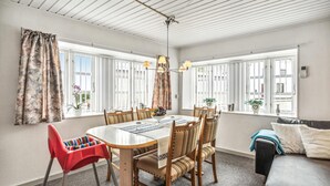 A dining area with a round table, chairs, and a red high chair.