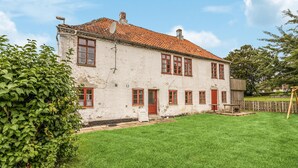 A two-story white building with red window frames and a red-tiled roof.