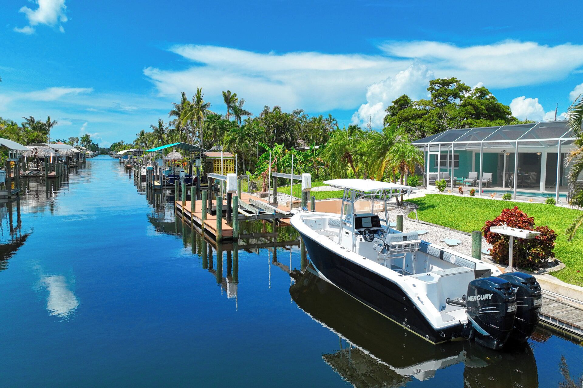 A boat docked at a marina with a covered area and a pool adjacent to it.