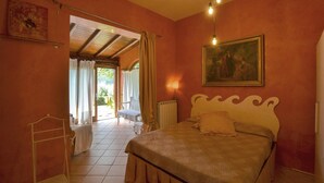 Une chambre à coucher avec un lit, un radiateur, un tableau et une vue sur l’extérieur.