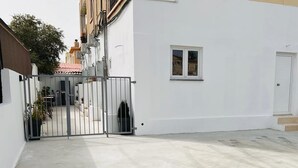 A gated courtyard with a white building, a small window, and a door. - Larnaca - Studio - Sleeps 4 - Garden - Parking (Larnaca)