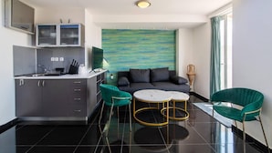 A modern kitchen with a dining area, a sofa, and a decorative wall. - Beautiful View 8floor Loft Apartment in Athina (Athens)