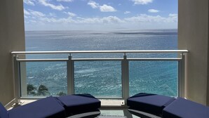 A balcony with a view of the ocean and a clear sky.
