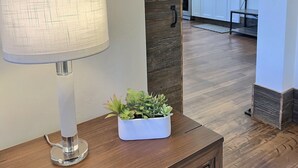 Eine moderne Küche mit weißen Schränken, einem eingebauten Ofen und einer Wand in Holzoptik.