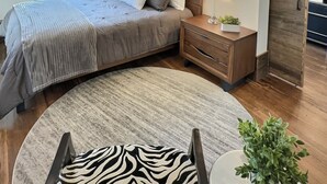 Ein Schlafzimmer mit Bett, Nachttisch, Lampe und Deckenventilator.