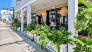 A building with a covered outdoor area, potted plants, and a sign indicating 'crave' with a logo. - Blue Moon Suite (St. Augustine)