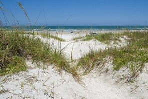 A beach with sand dunes and sparse vegetation. - Castillo del Sol (St. Augustine)