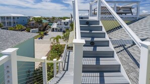 Eine moderne Brücke mit Metallgeländer und einer Treppe, die zu einem Gebäude mit einer grünen Dachbegrünung führt.