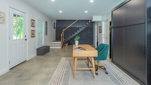 Ein modernes Interieur mit einer Treppe, einem Schreibtisch mit Stuhl und einem großen Kleiderschrank.
