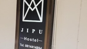 A framed sign with the text "JIPU Hostel" and a telephone number. - Jipu Homestay Ai Yoe Boe Chang (Betong)
