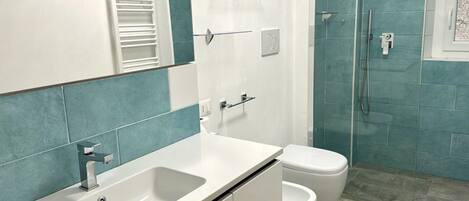 Een douche, een haardroger, een bidet, handdoeken