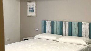 Slaapkamer met een bed, nachtkastje, wanddecoratie en een hoofdbord met strepen.