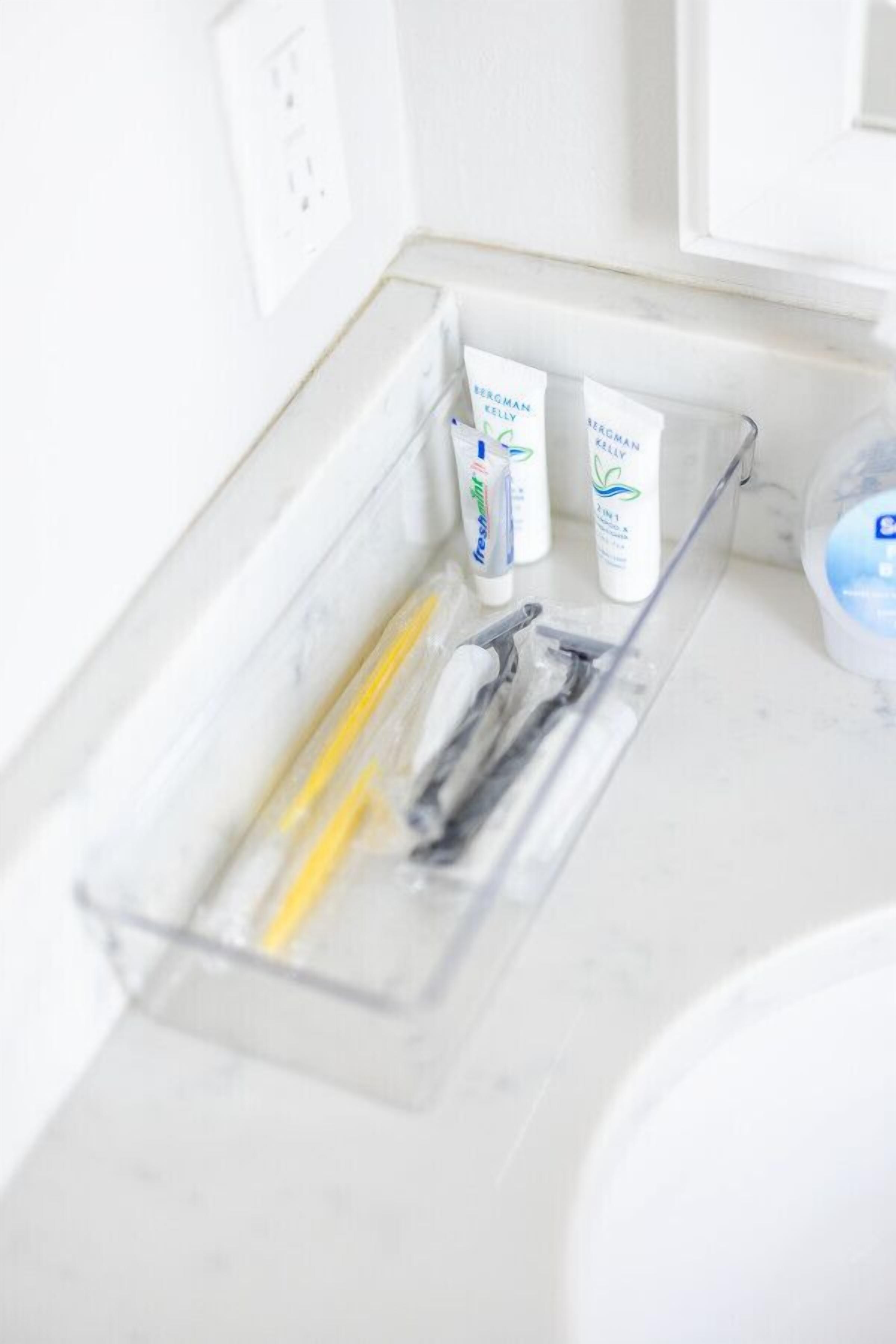 A bathroom with a clear plastic organizer holding toiletries.