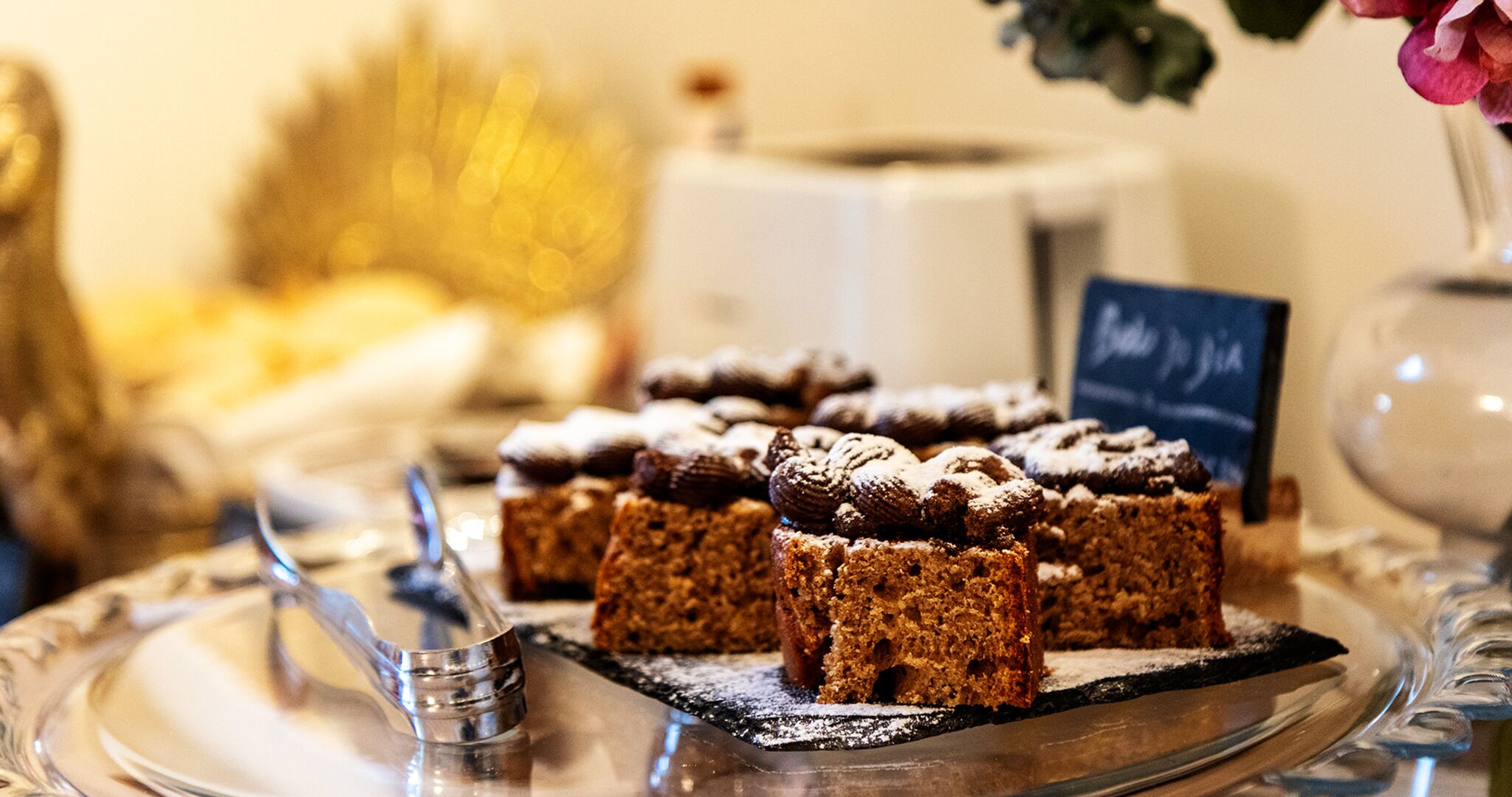 A tray of desserts on a reflective surface with a blurred background.