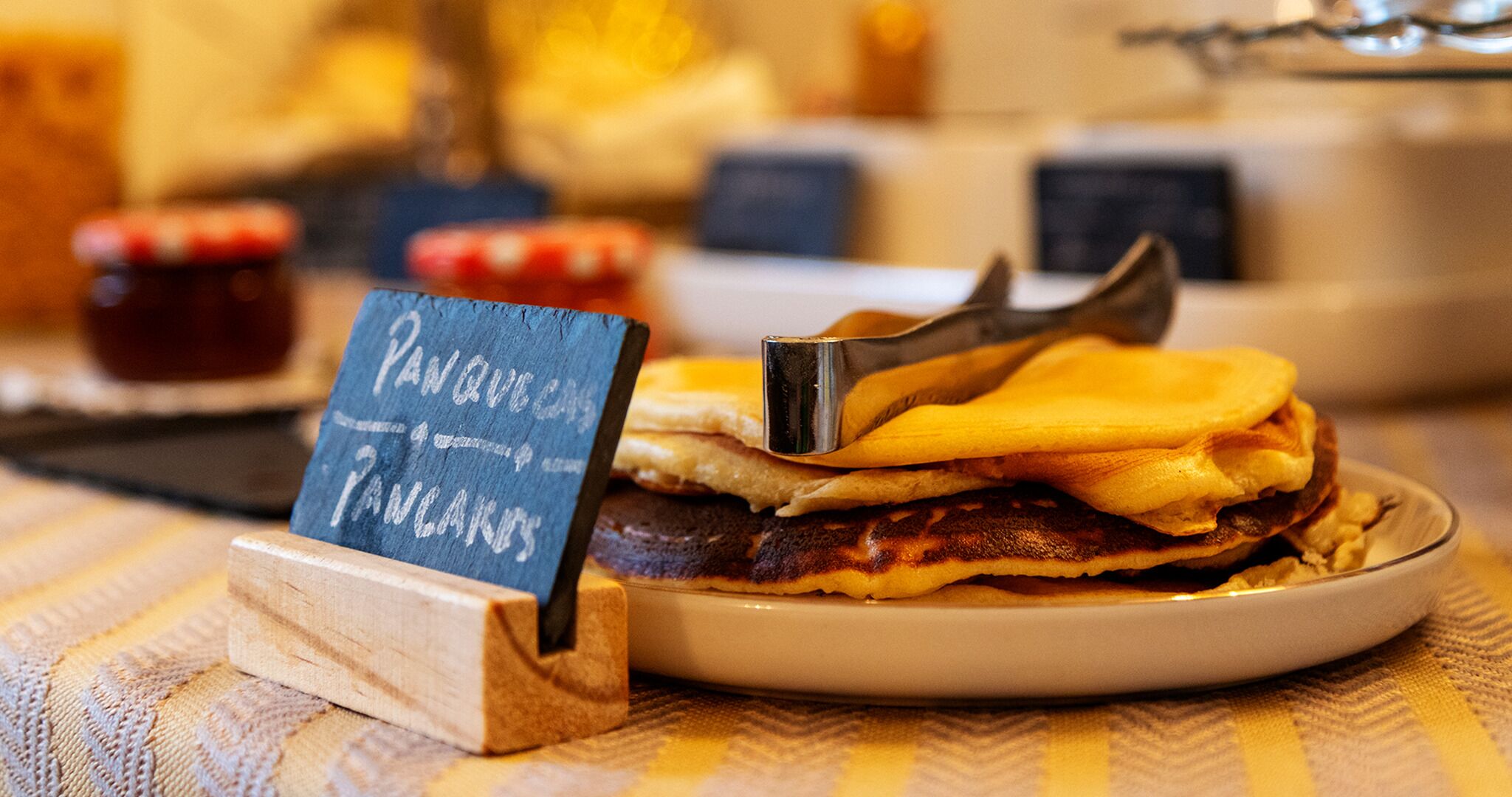 A breakfast plate with pancakes and a sign indicating 'PANQUELAS PANCAKES'.