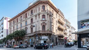 A historic building with a corner entrance, a visible shop with a sign, and a clear street view. - GuestHost - Bright apartment that accommodates up to 4 people, equipped with all the comforts for a pleasant stay, with two bedrooms and a panoramic terrace that offers a beautiful view of the Maiella and Gran Sasso mountains. The accommodation is locate (Pescara)