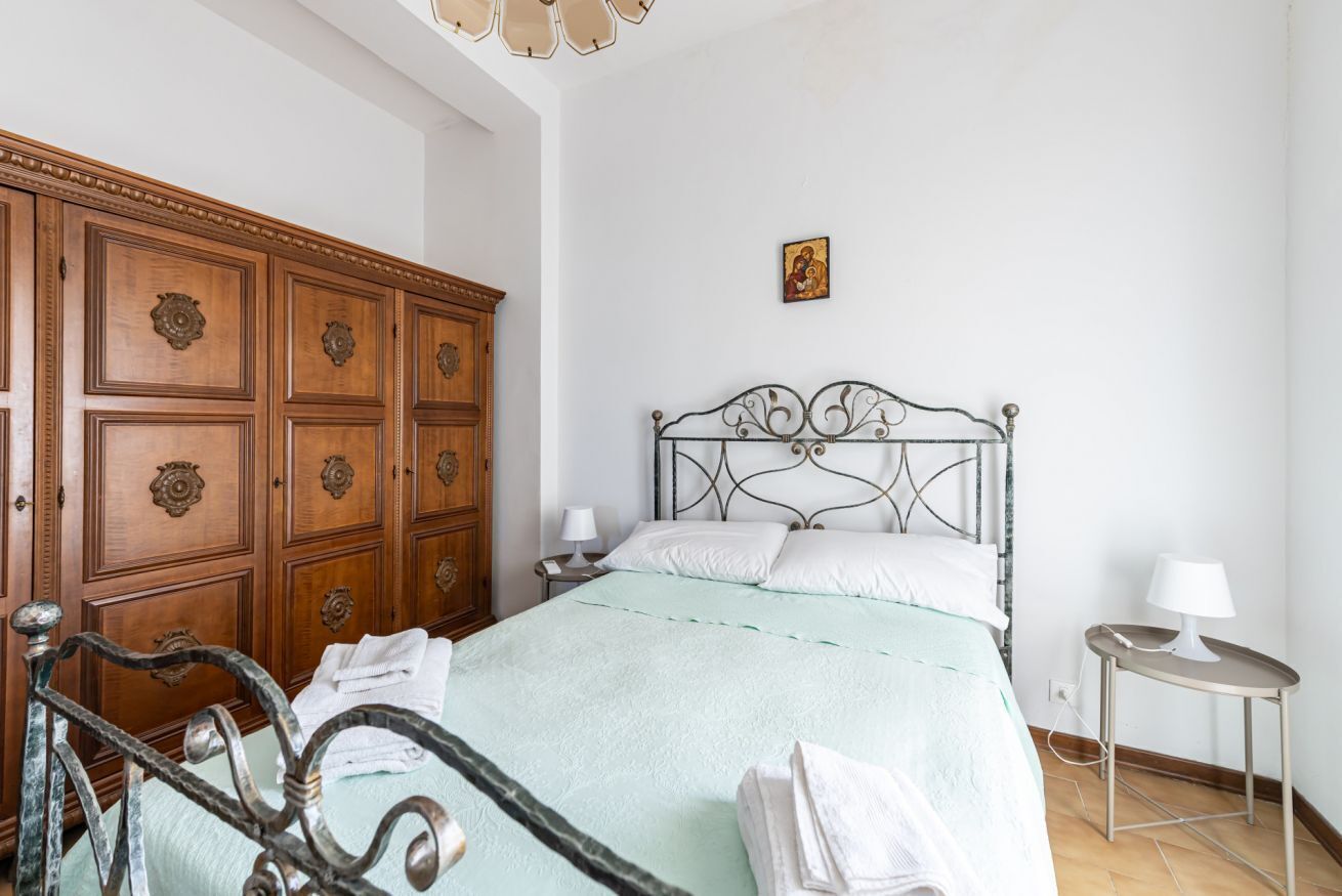 Ein Schlafzimmer mit Bett, Holzschrank und Nachttisch.