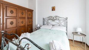 A bedroom with a bed, wooden wardrobe, and a bedside table. - GuestHost - Bright apartment that accommodates up to 4 people, equipped with all the comforts for a pleasant stay, with two bedrooms and a panoramic terrace that offers a beautiful view of the Maiella and Gran Sasso mountains. The accommodation is locate (Pescara)