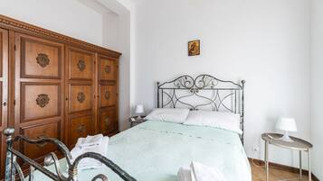 Ein Schlafzimmer mit Bett, Holzschrank und Nachttisch.