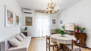 A dining area with a round table, chairs, a chandelier, and artwork on the walls. - GuestHost - Bright apartment that accommodates up to 4 people, equipped with all the comforts for a pleasant stay, with two bedrooms and a panoramic terrace that offers a beautiful view of the Maiella and Gran Sasso mountains. The accommodation is locate (Pescara)
