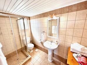 A bathroom with a glass-enclosed shower, a white sink, and a wooden vanity with towels. - Stunning Greek Villa-private pool-beach-sleeps 8 (Sykia)