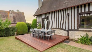 Una casa con terraza, una mesa de comedor y sillas.