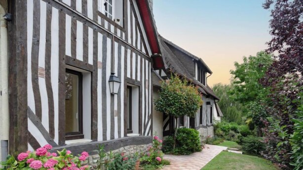 Una casa tradicional con entramado de madera y un camino empedrado que conduce a la entrada.