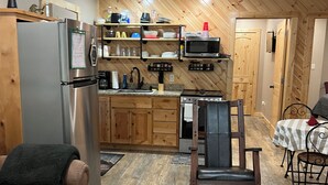 Un espacio habitable compacto con kitchenette, comedor y sofá.