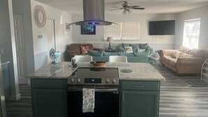 A modern kitchen with a central island, built-in oven, and stainless steel range hood. - Beach House Kids & Pets OK Oct, Nov, Dec DISCOUNTED! AMIsland White Sand Beaches (Bradenton)