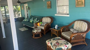 A covered porch with wicker furniture, a cushioned bench, and a ceiling fan. - Beach House Kids & Pets OK Oct, Nov, Dec DISCOUNTED! AMIsland White Sand Beaches (Bradenton)