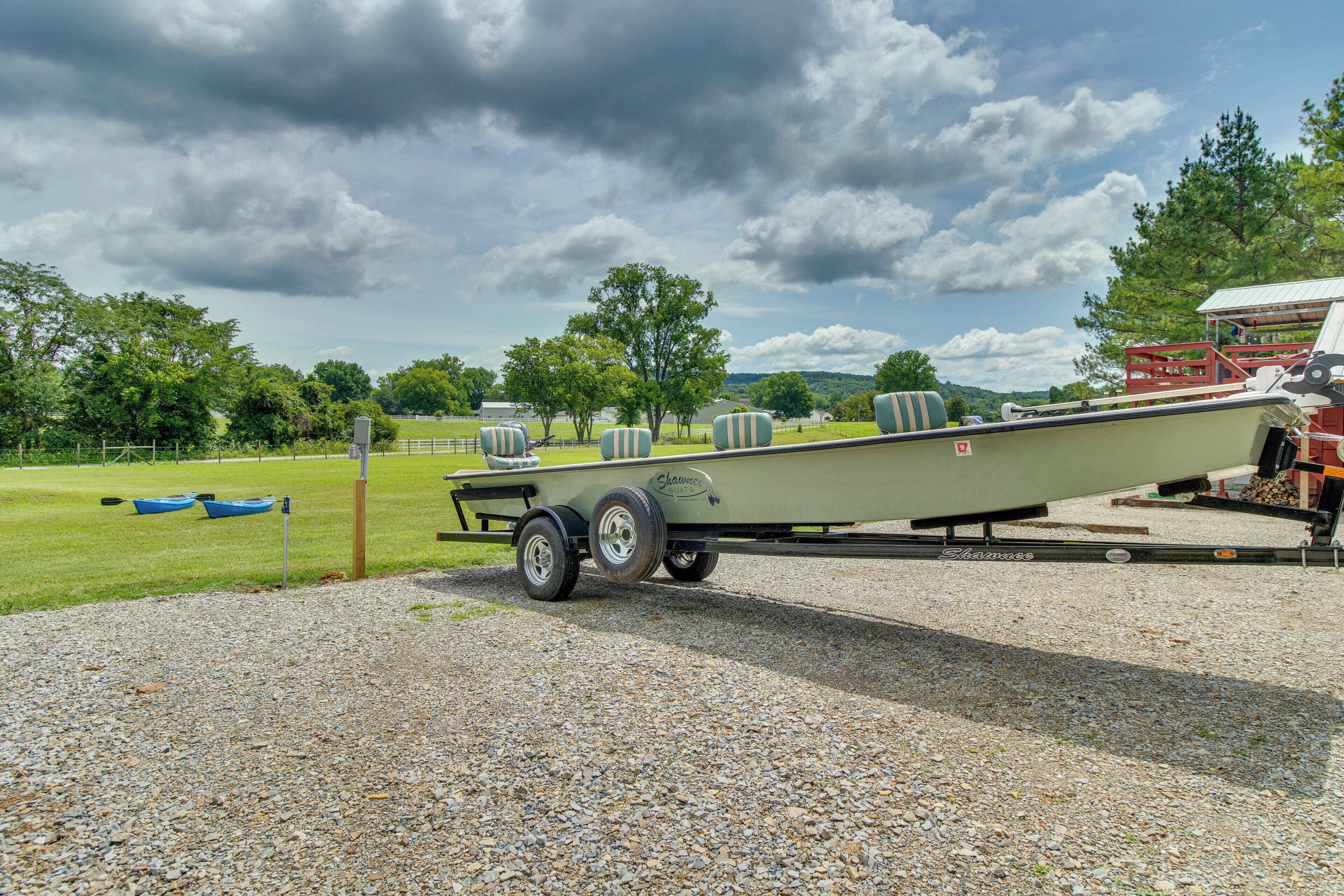 A boat trailer with a boat on it, parked on a gravel surface.