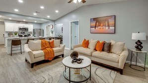 A spacious living area with a sofa, coffee table, and a painting on the wall. - Atlanta Getaway w/ Private Yard: Near Airport (Atlanta)