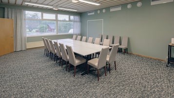 A conference room with a large table, chairs, and a projector.